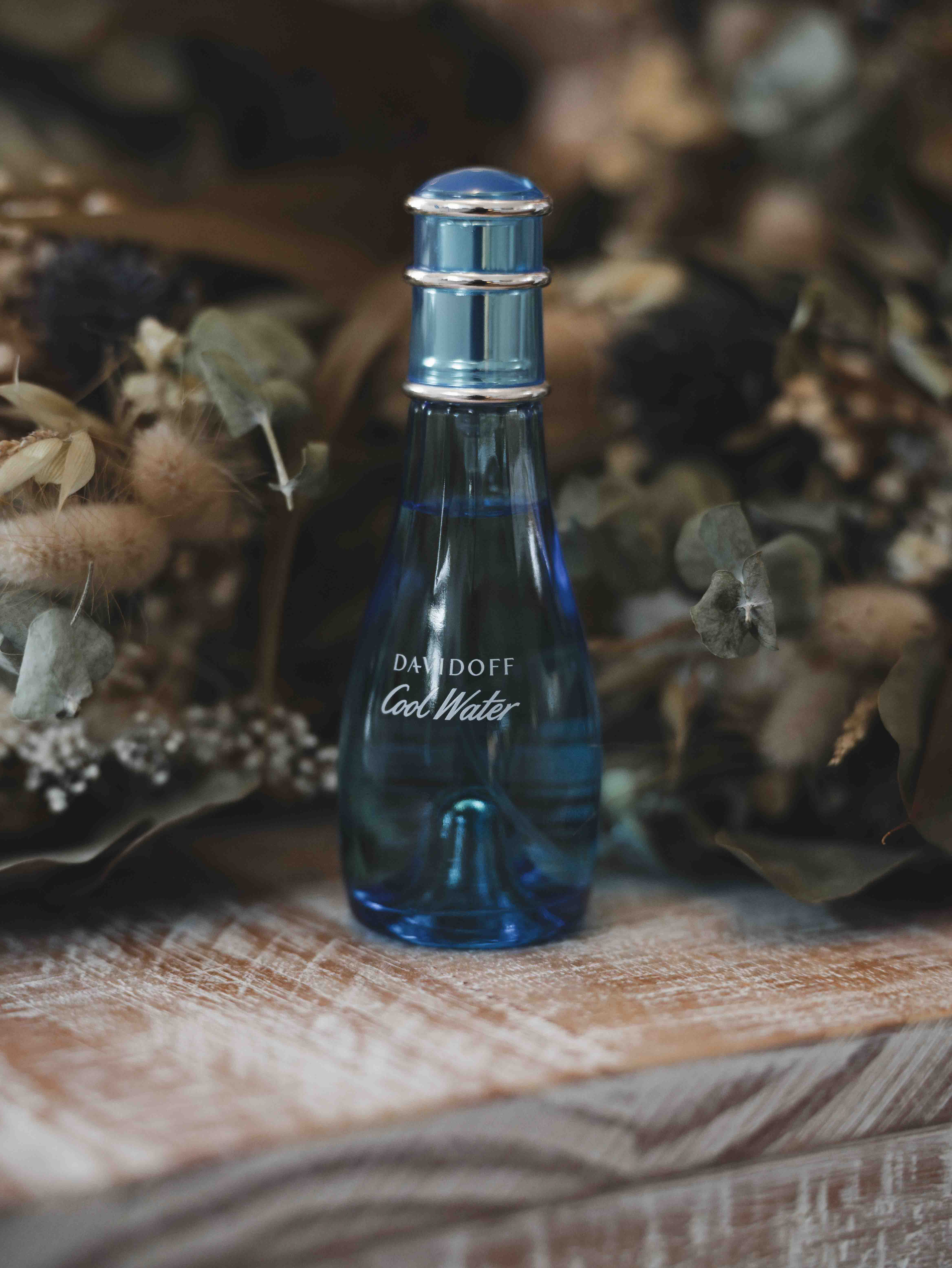 Bridal details with perfume bottle and dried flowers on rustic wood surface