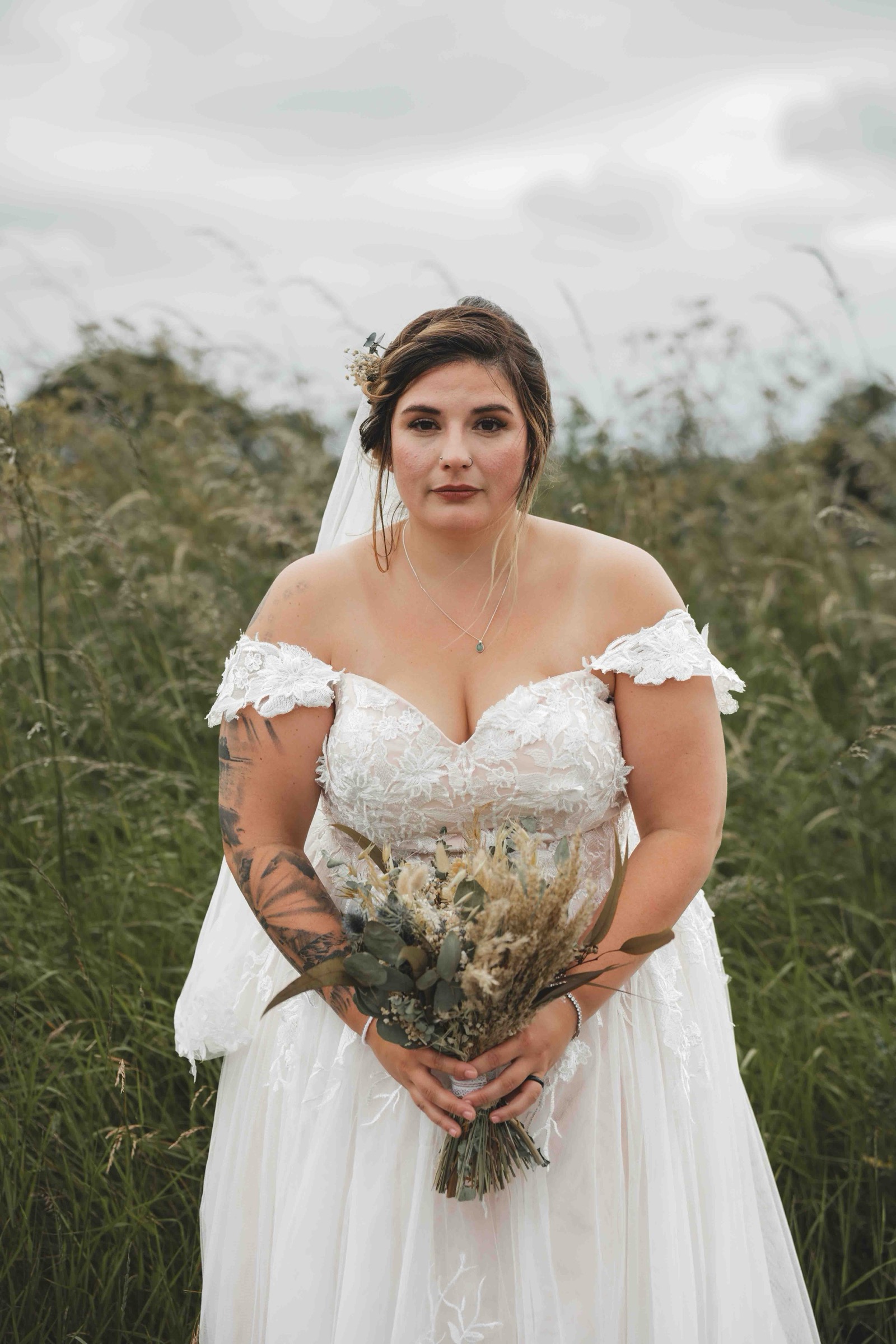 Cessca solo portrait holding her dried flower bouquet in tall golden grass