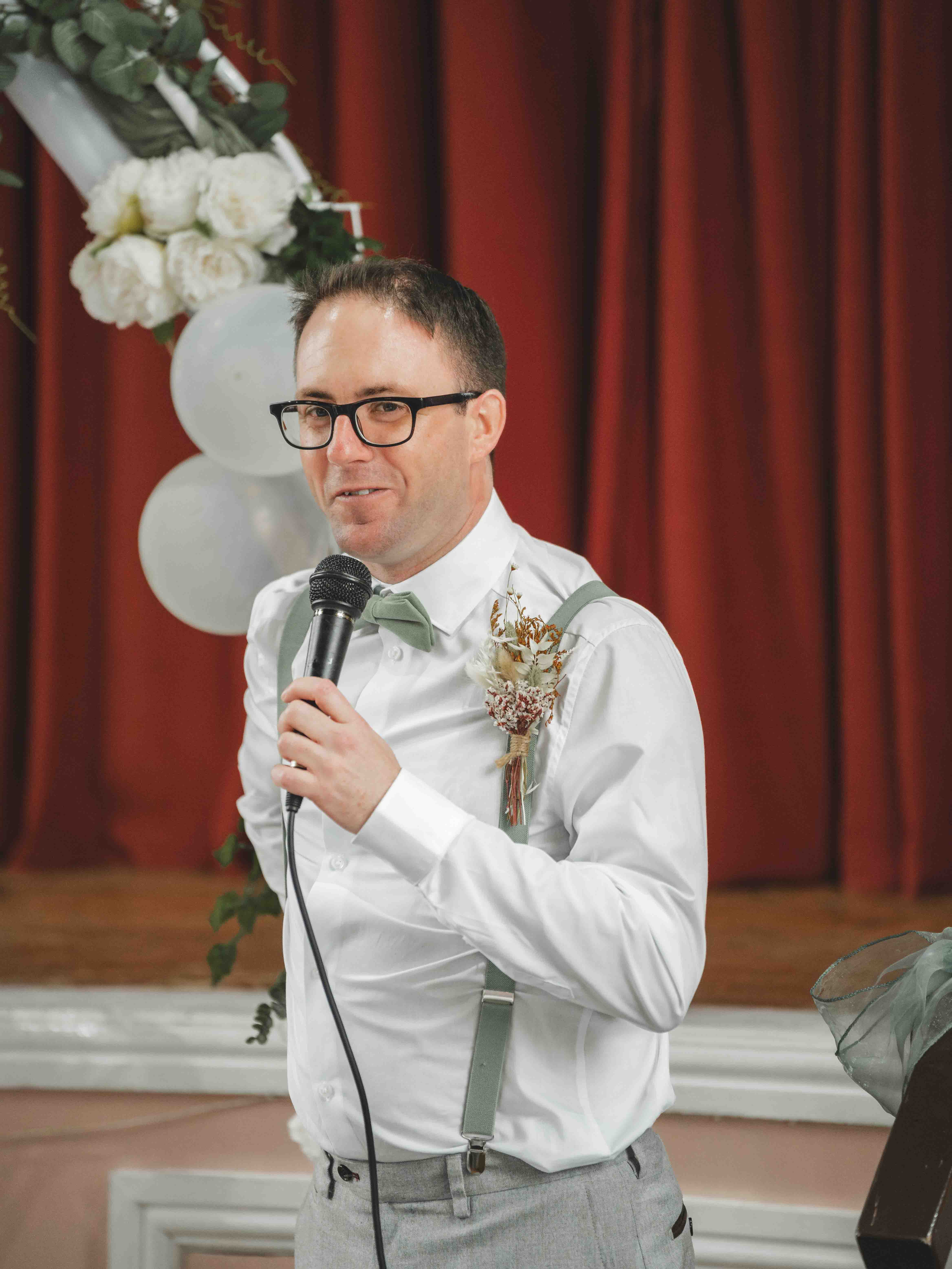 Best man delivering his speech with microphone during the wedding reception