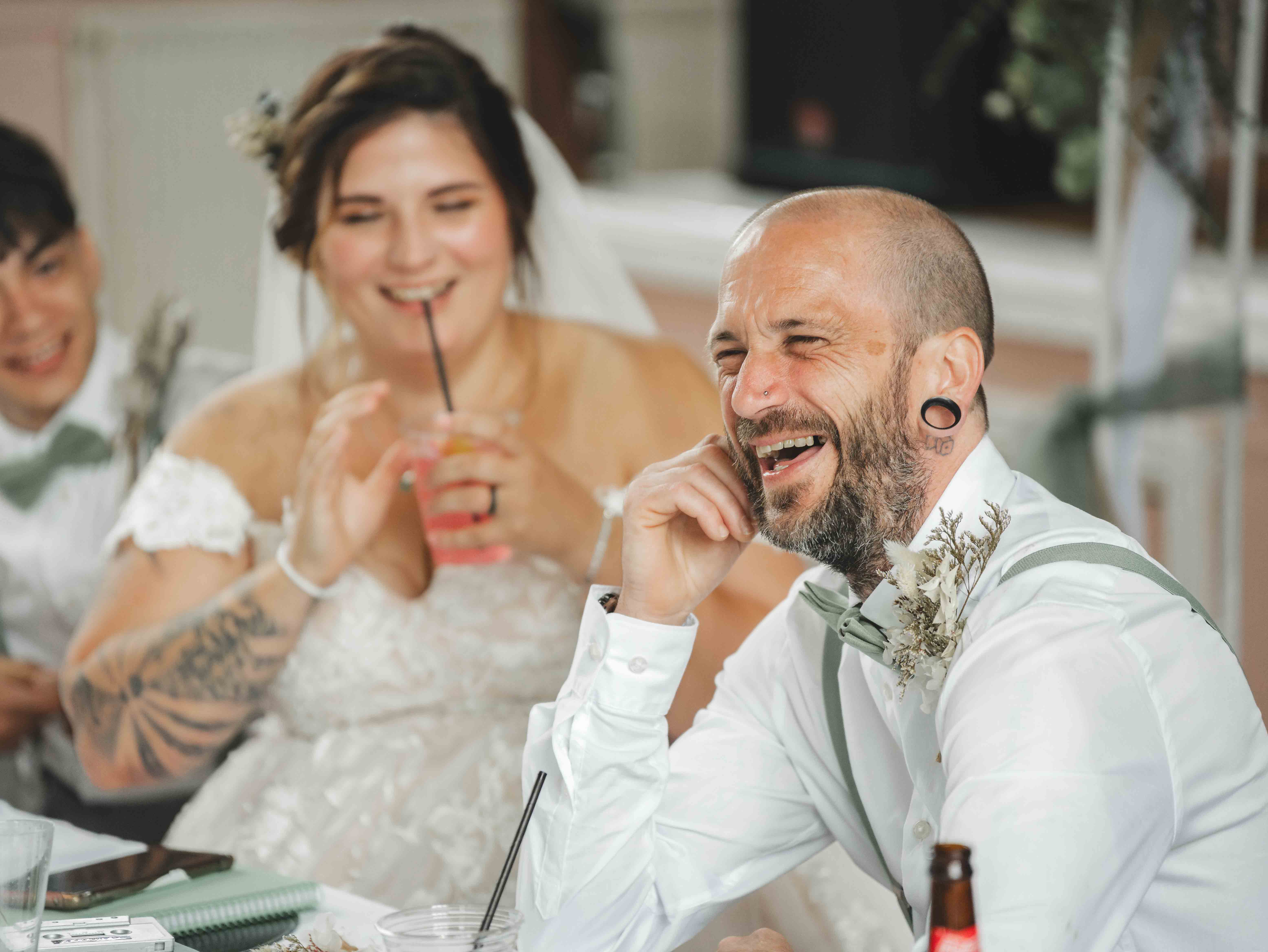 Cessca and Tony laughing together at the reception table during the wedding breakfast