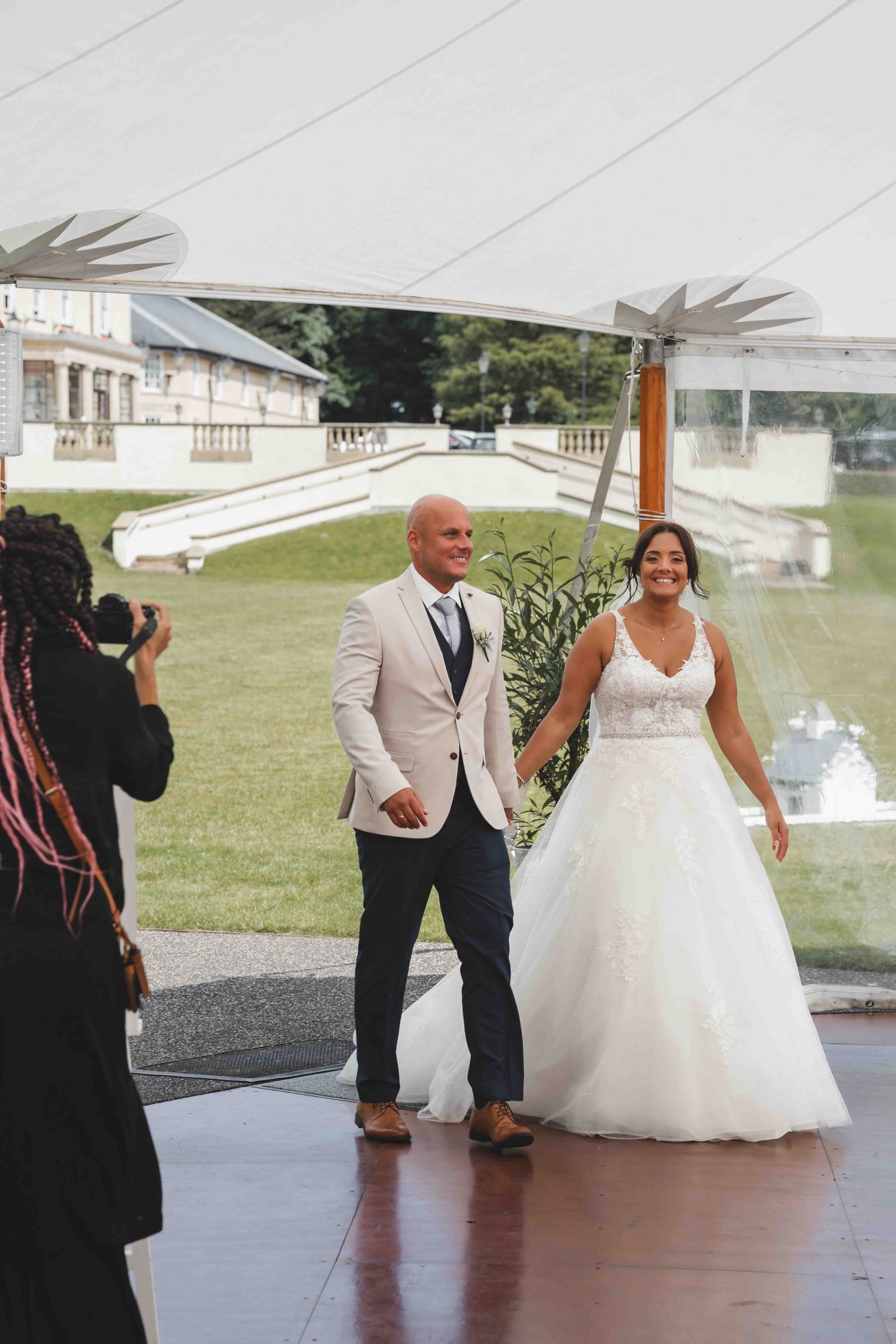 Lauren and John walking through wildflower meadows at golden hour