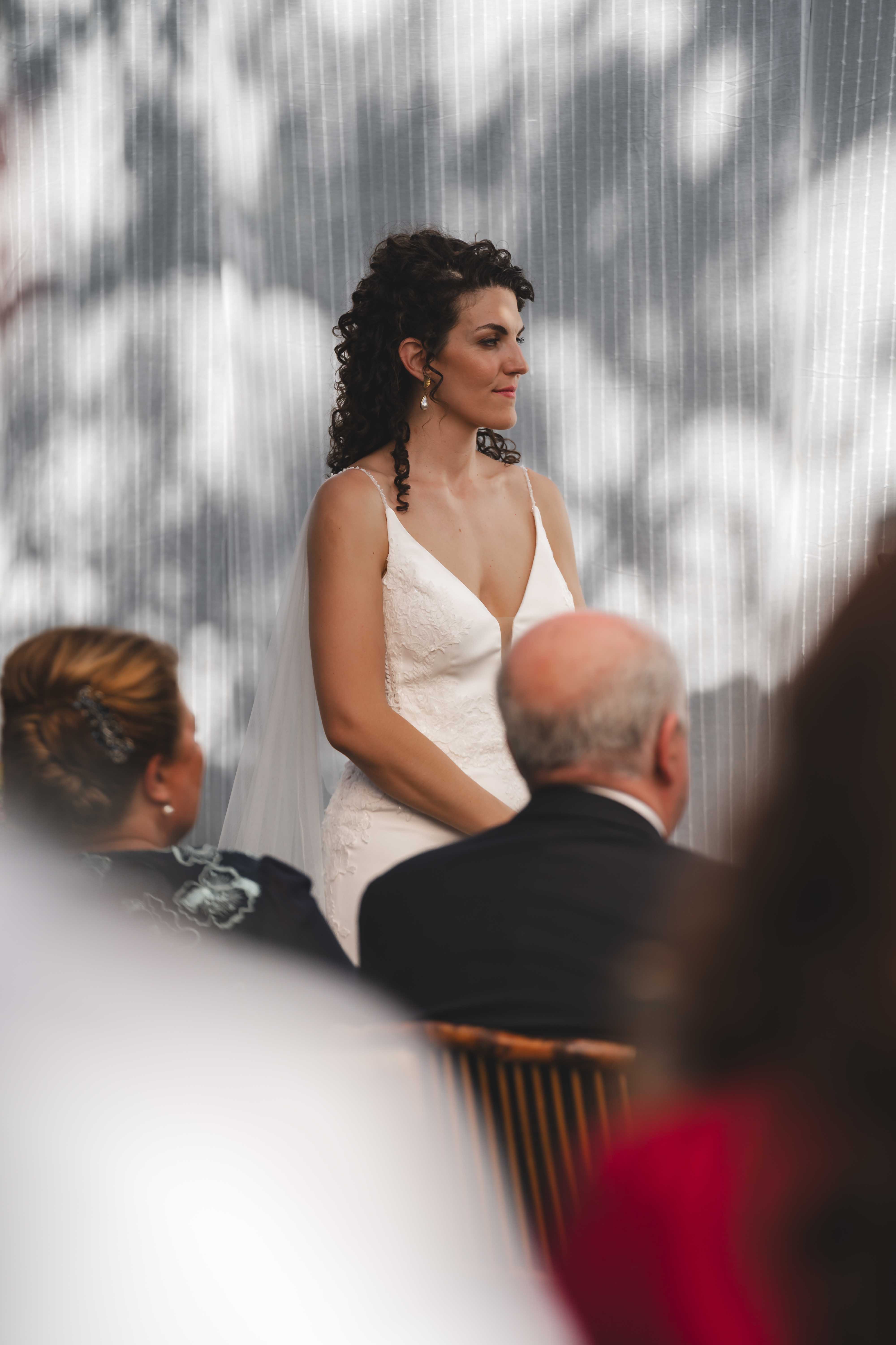 Maria during the wedding ceremony in an elegant v-neck wedding dress with veil