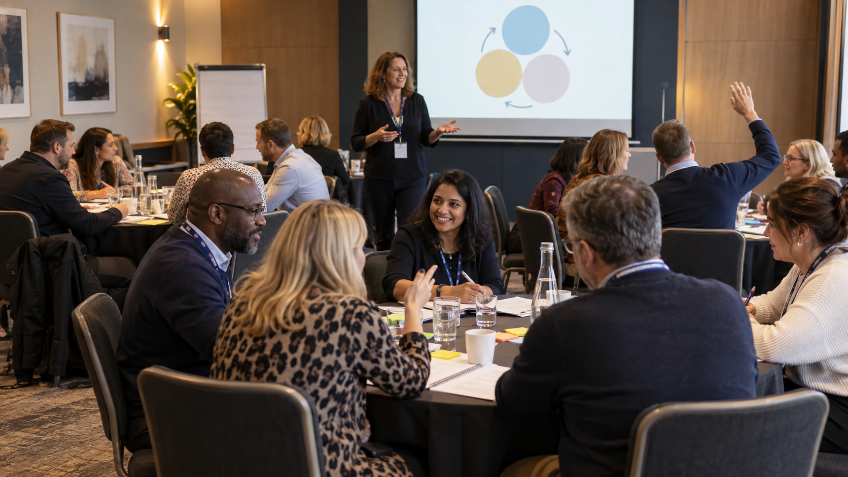 Conference workshop with delegates discussing ideas around tables